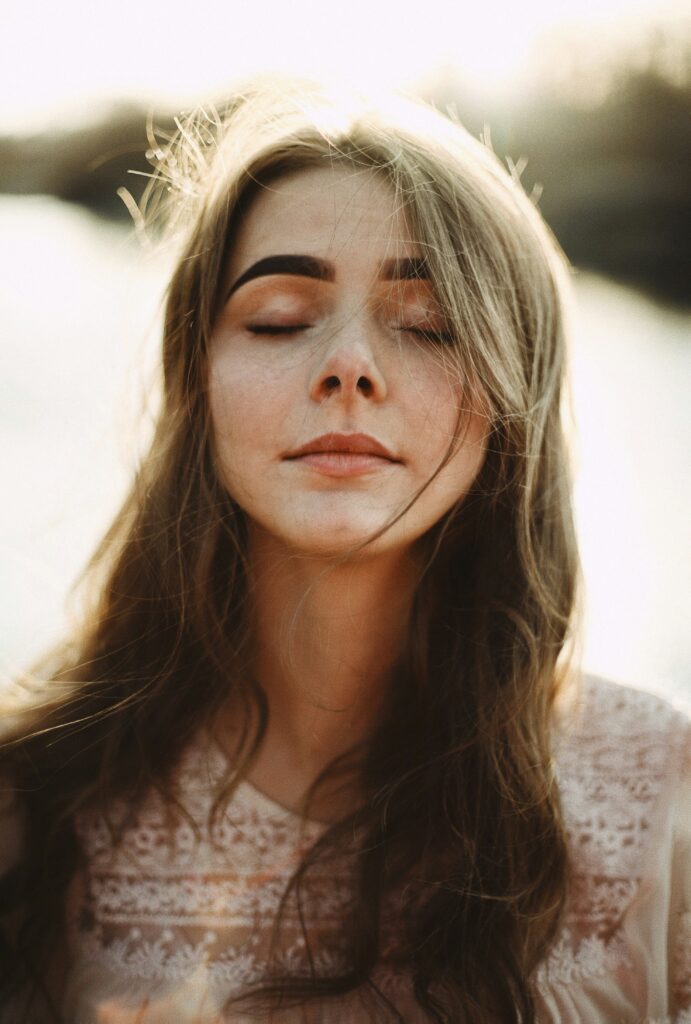 A girl with eyes closed at peace breathing and reflecting on new beginnings