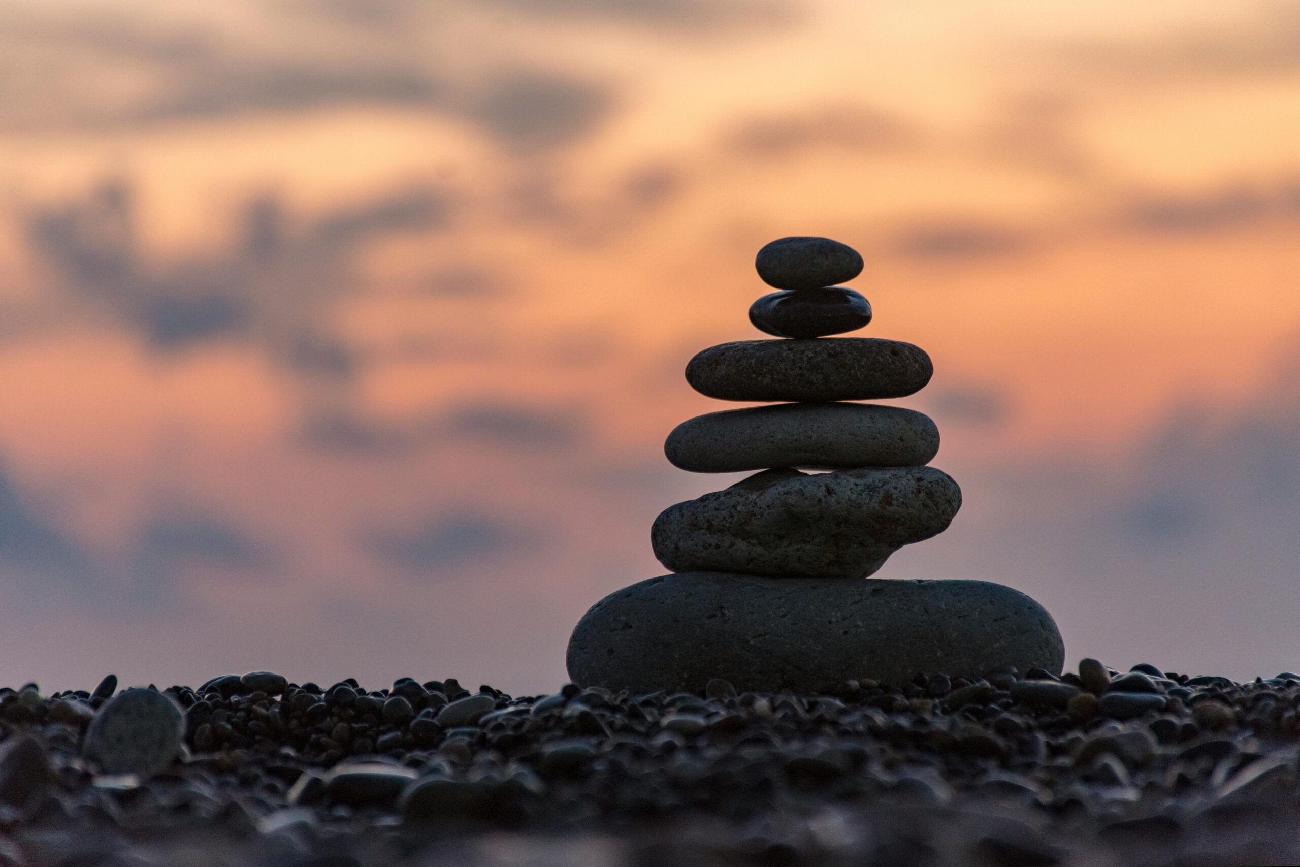 A stack of rocks at sunrise for peace and balance for your mental health