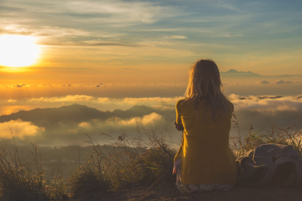 Girl watching the sunrise from mountain