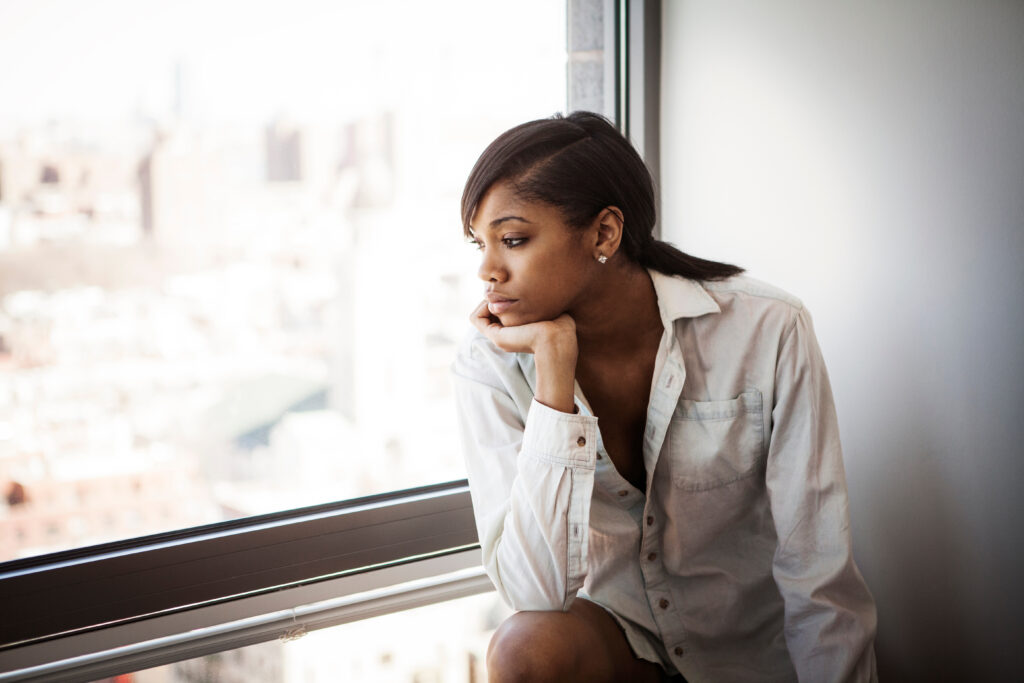 Young woman looking through window