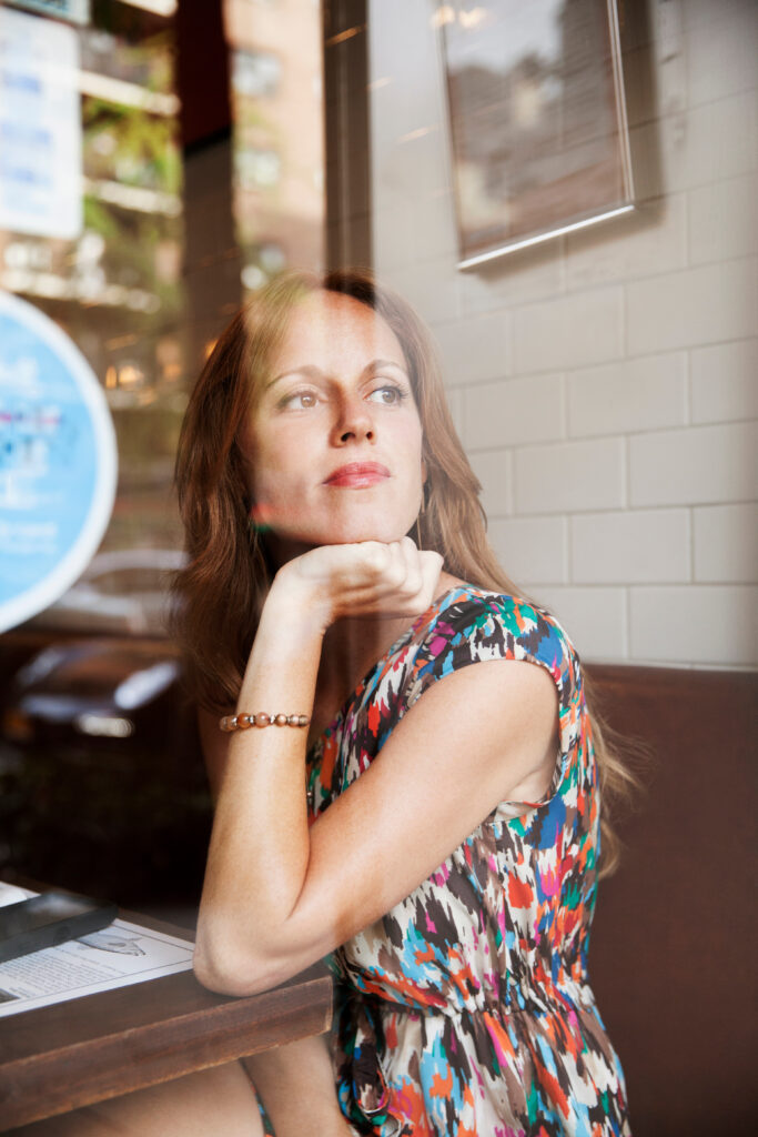Woman looking through window reflecting