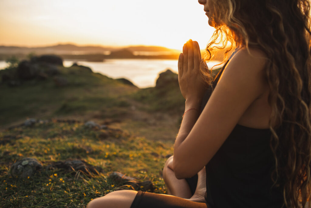 woman meditating alone at sunrise. Nature background. Spiritual and emotional concept. Sensitivity to nature