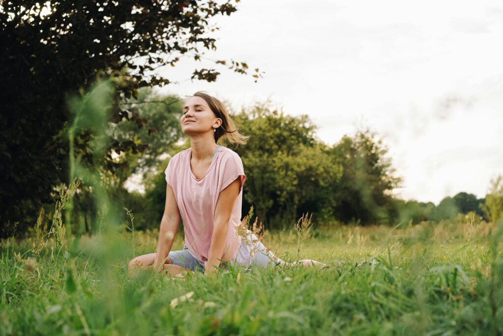 woman stretching in field smiling enjoying the sun