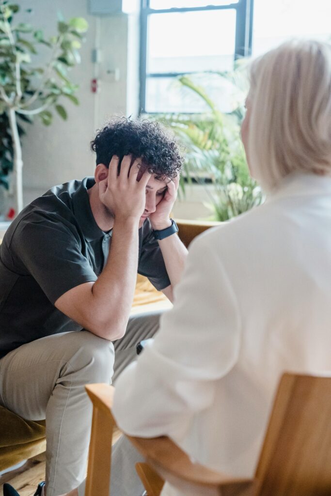 young man looking anxious talking to therapist