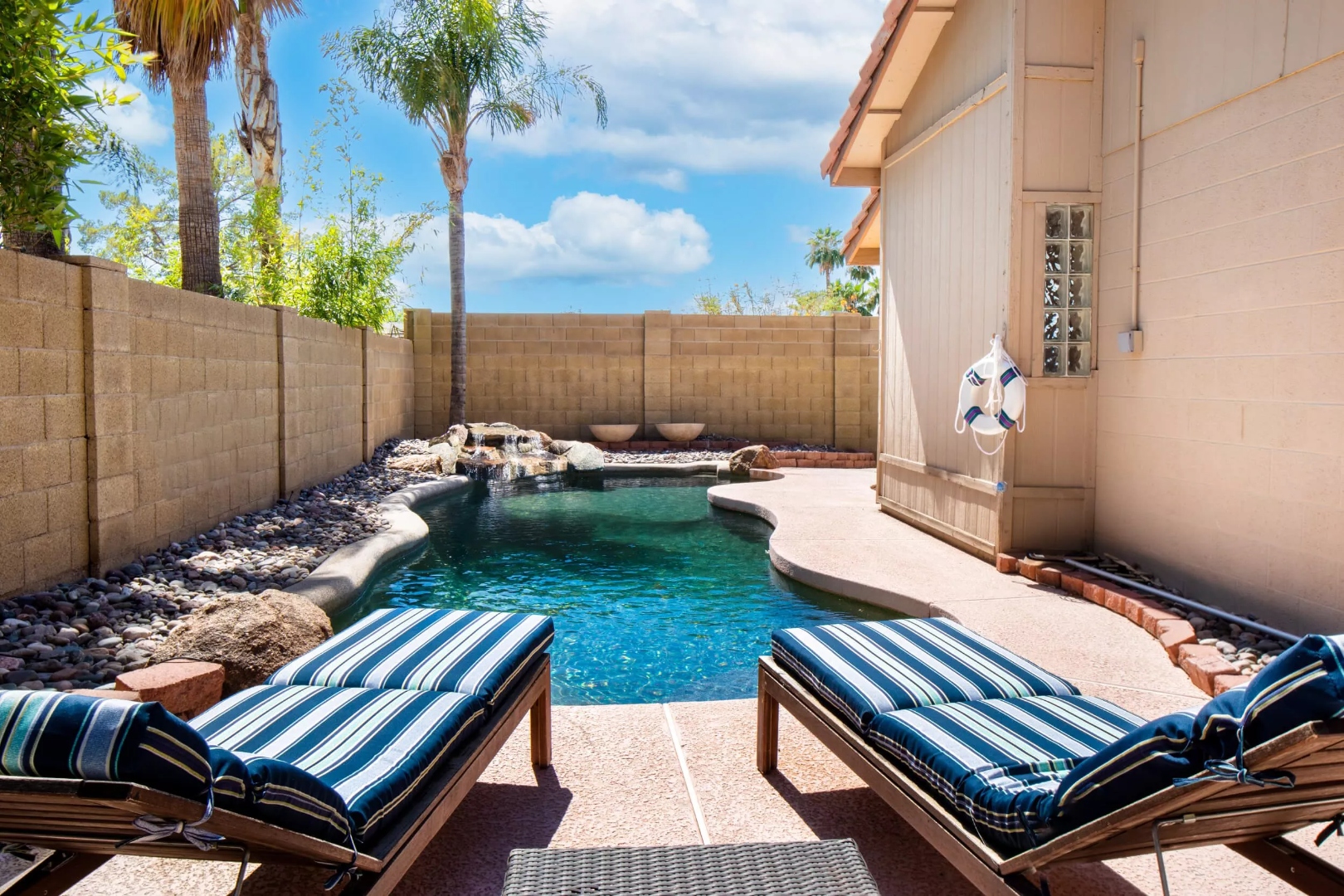 Backyard pool with lounge chairs at Cholla, a residential location for men