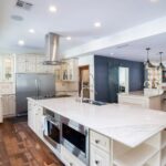 A white kitchen with a large island at Mariposa, a residential location for women